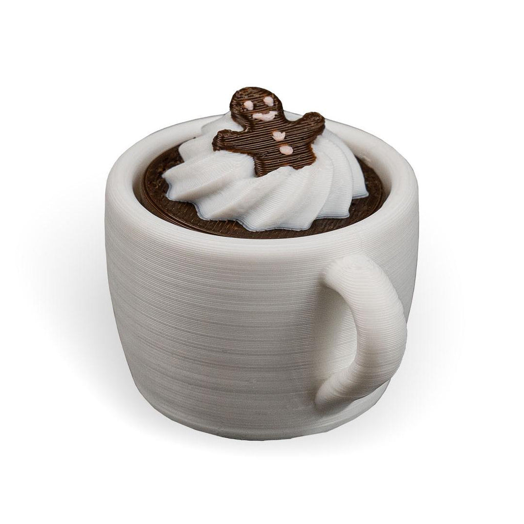 White ceramic mug with a gingerbread man figure in a wedding dress on top of hot chocolate.