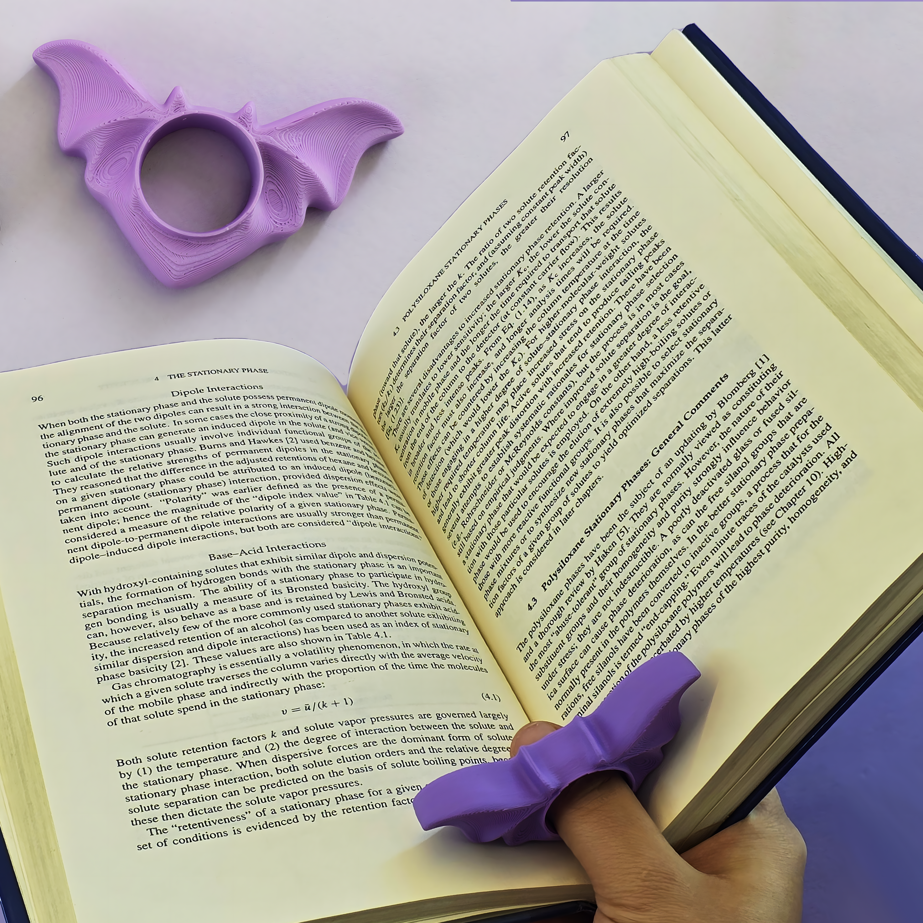 Purple bat-shaped book marker on an open book