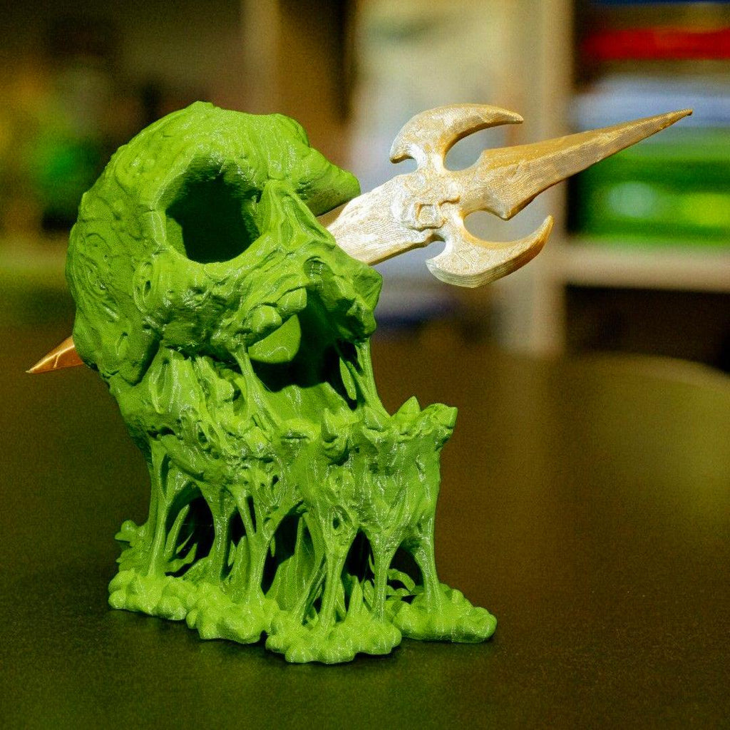 Green and beige fantasy creature figurine on a dark surface