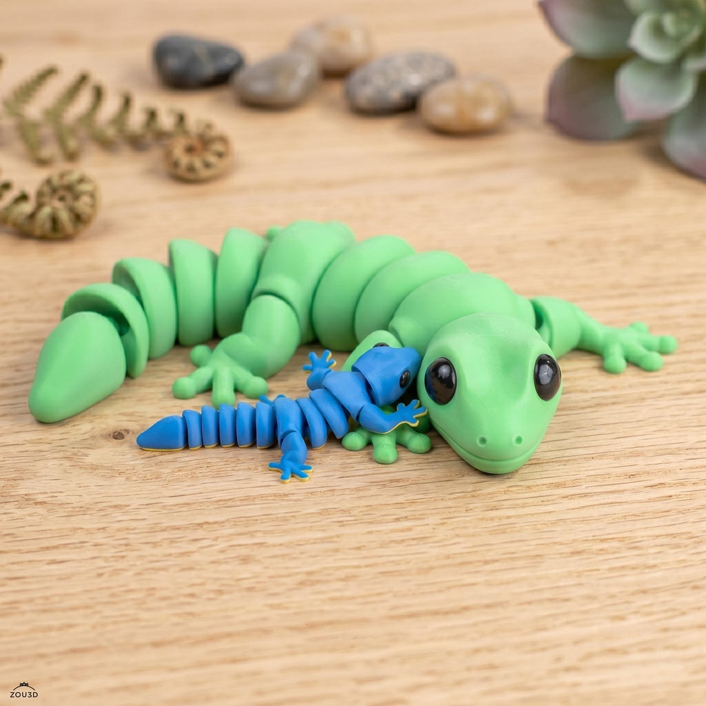 Large green articulated gecko curled beside a small blue one