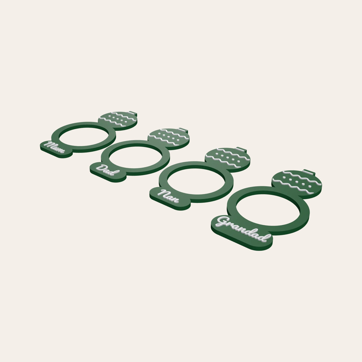 Four green napkin rings with bauble toppers, each with a family name such as Mum or Grandad