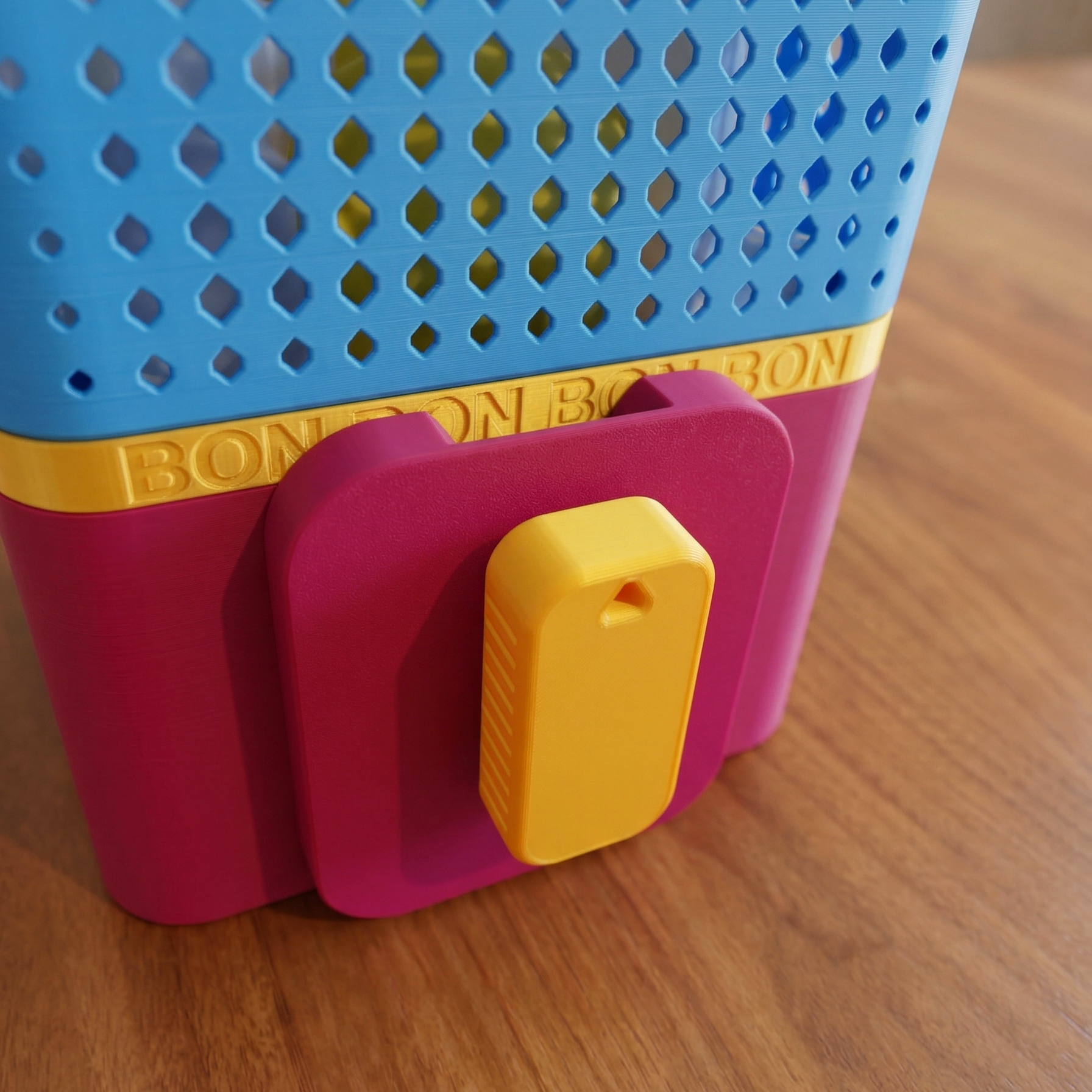 Colorful plastic toy with 'BON BON' branding on a wooden surface