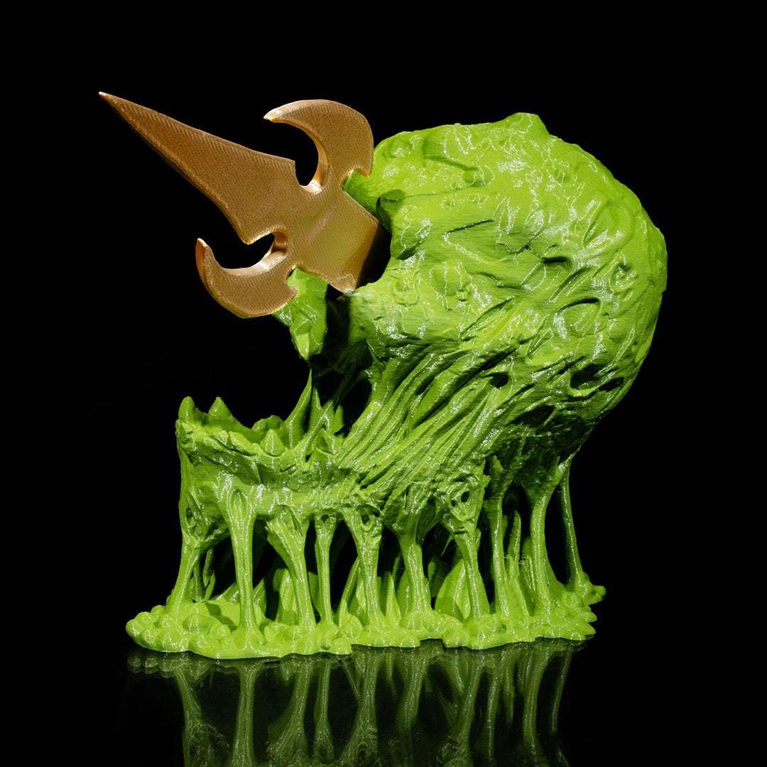 Green and gold fantasy creature figurine on a black background