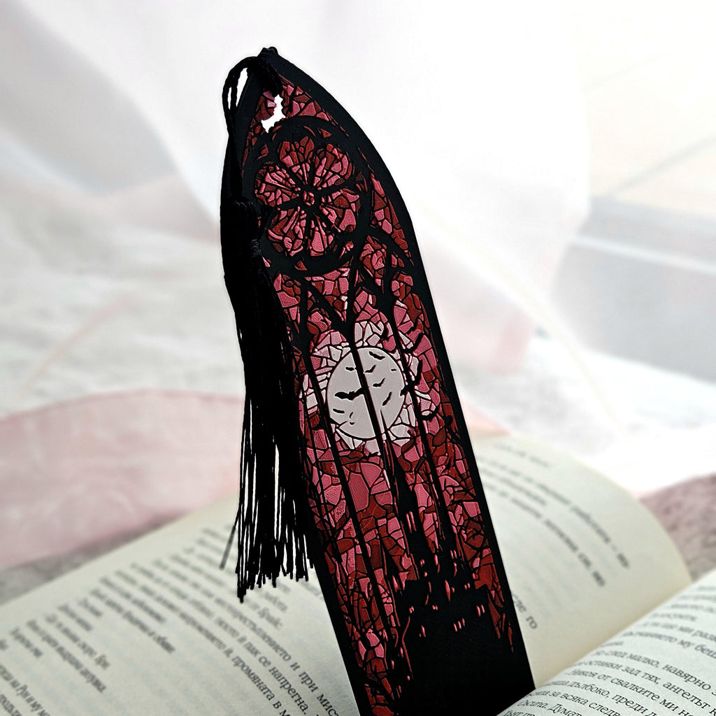 Stained glass bookmark with a castle and full moon, standing in an open book
