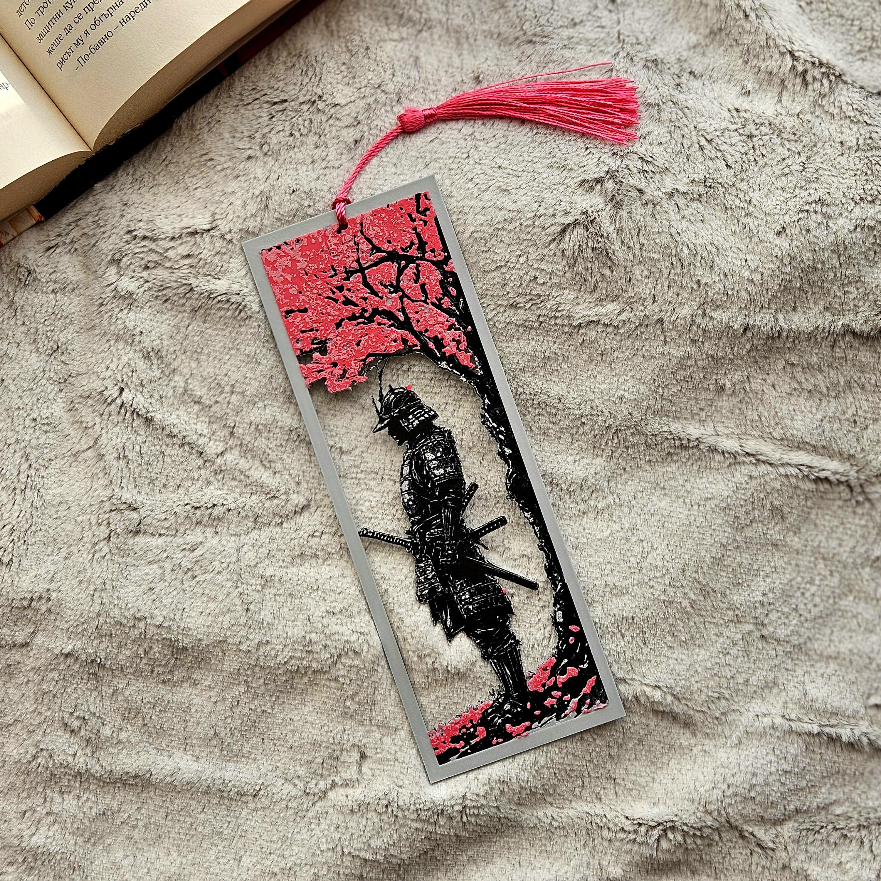 Decorative bookmark with a black and red design on a textured surface