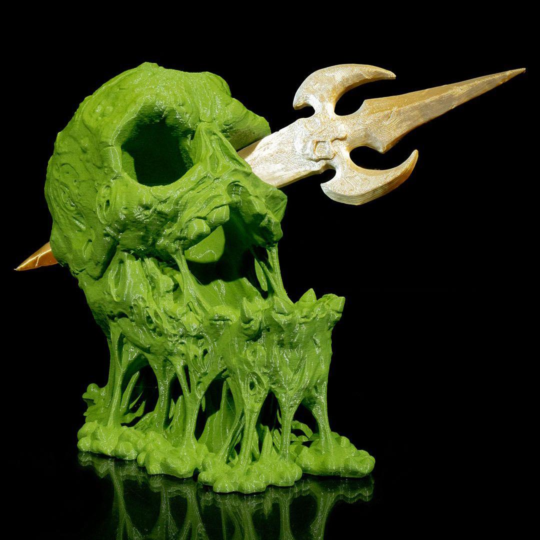 Green and beige fantasy creature figurine with large horn on a black background