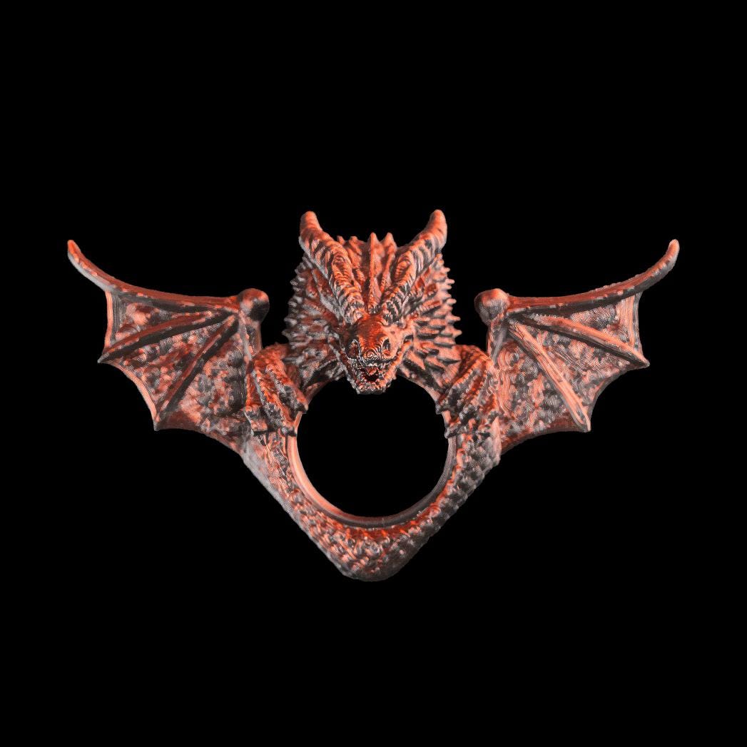 Dragon page holder from the front, wings spread, with the thumb ring below