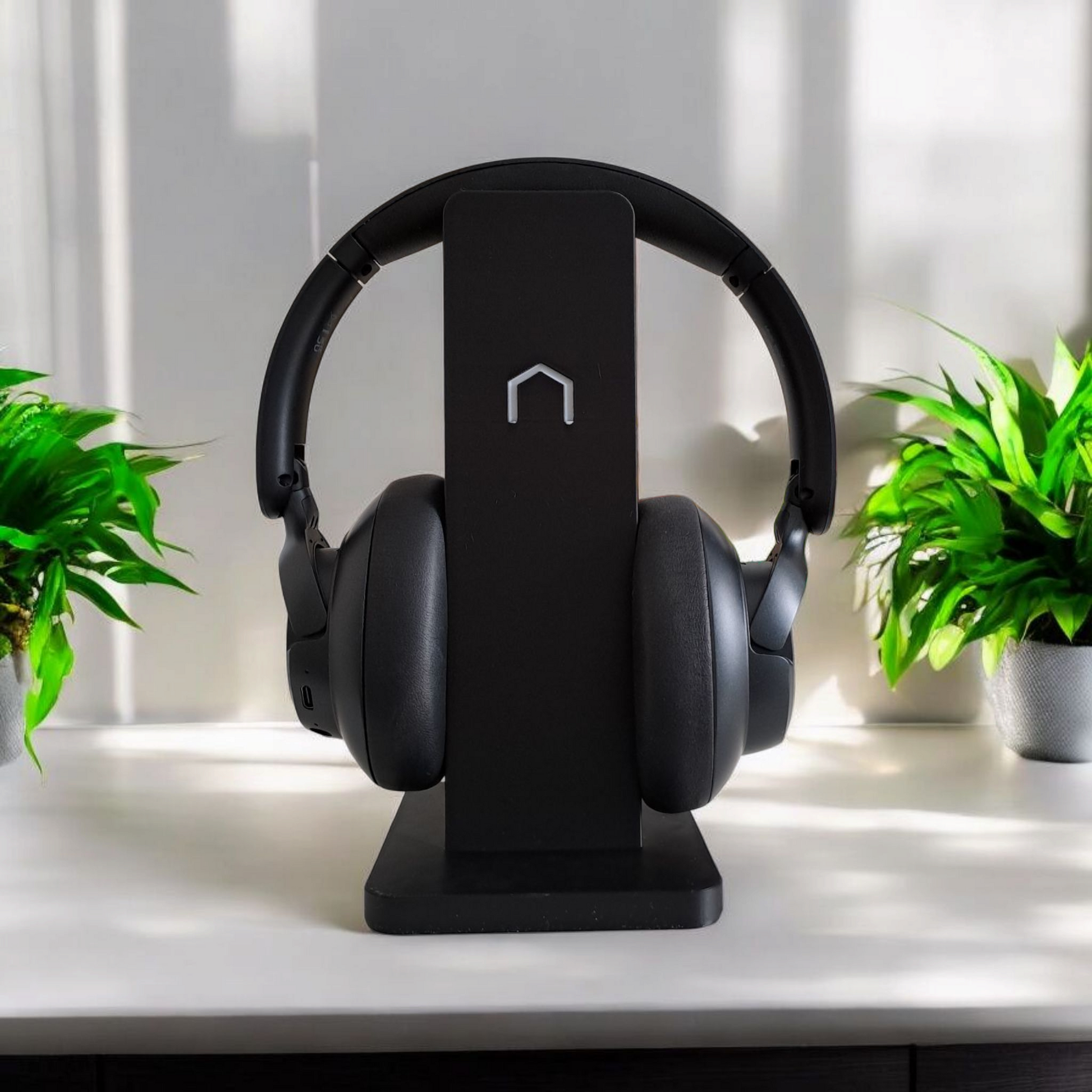Black modern minimalist headphone holder on a clean desk