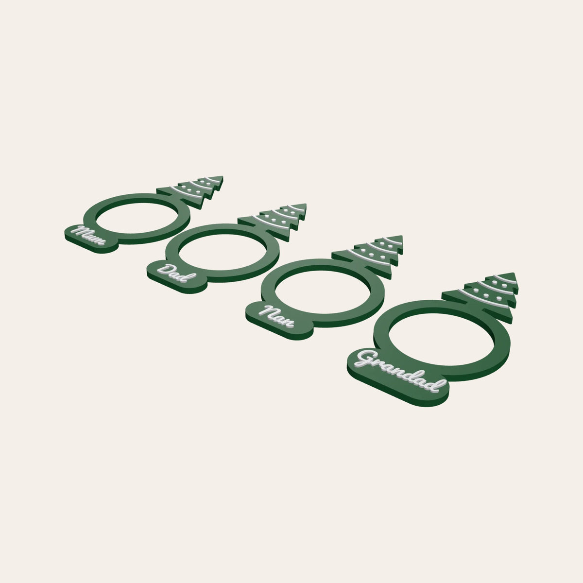 Four green napkin rings with Christmas tree toppers, each with a family name such as Mum or Grandad
