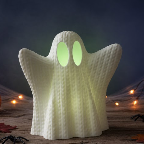Ghost-shaped night light with glowing eyes on a Halloween-themed background