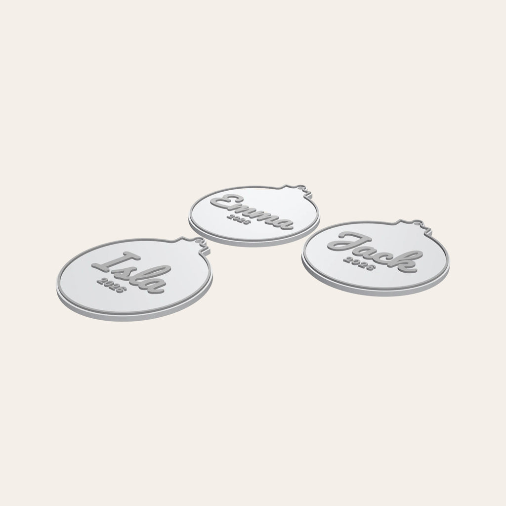 Three personalised bauble ornaments in white and silver, each with a name and the year